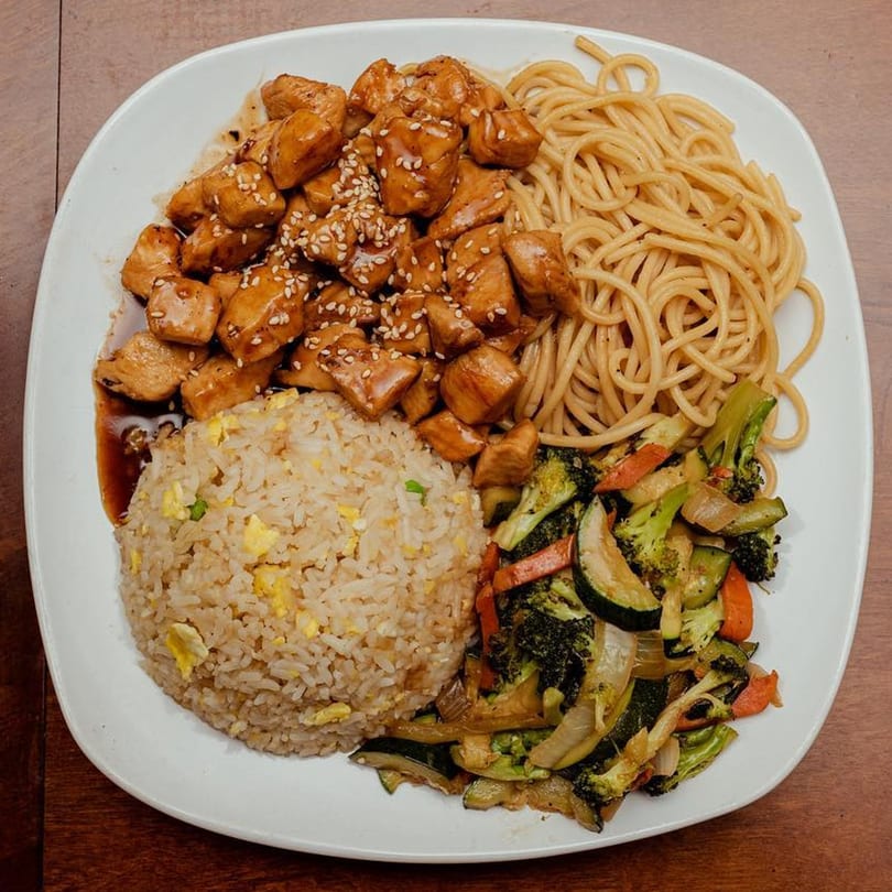 Oishii Hibachi Grill's chicken hibachi with fried rice, noodles, and mixed vegetables on a white plate.